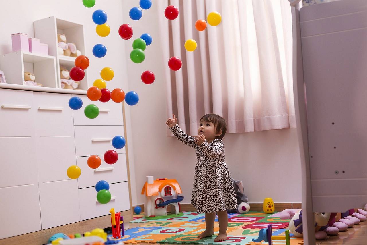 Dziewczynka bawi się zabawkami w swoim pokoju